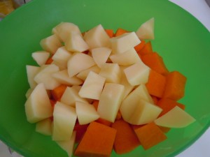 Per preparare la vellutata di zucca, lavare e sbucciare la zucca e le patate e tagliarle a pezzetti.